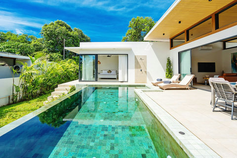 Stunning daytime pool view with outdoor entertainment area and tropical garden surroundings
