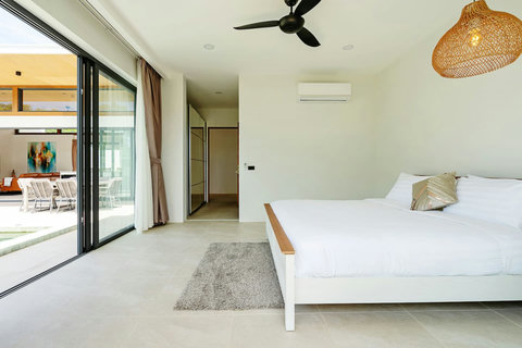 Bright bedroom with ceiling fan and garden-view sliding doors