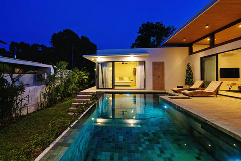 Magical twilight poolside view - Villa exterior showcasing tropical landscaping and elegant design