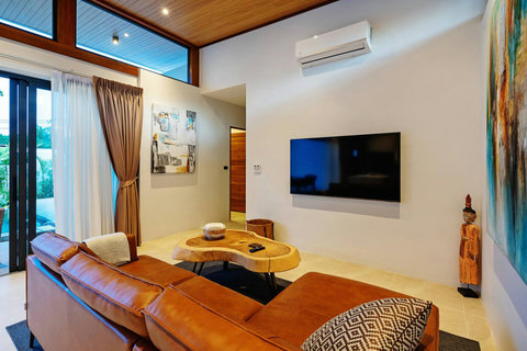 Comfortable living area with large flat-screen TV - Entertainment space with colorful furnishings