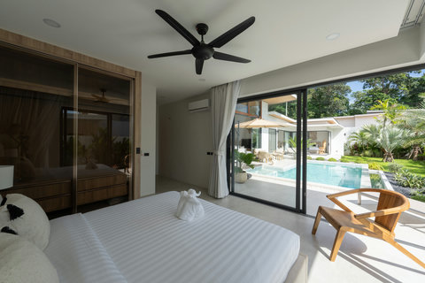 Bright bedroom in Koh Samui villa with pool views ceiling fan and sliding door access