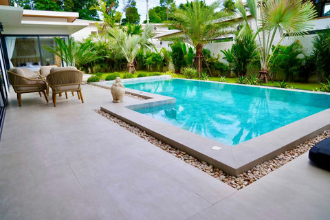 Swimming pool with sun loungers in private Bophut villa with lush tropical gardens