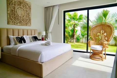 Bright bedroom in Koh Samui rental with garden views and hanging rattan chair