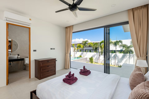 Elegant master bedroom with panoramic pool and garden views through floor-to-ceiling windows and private terrace access