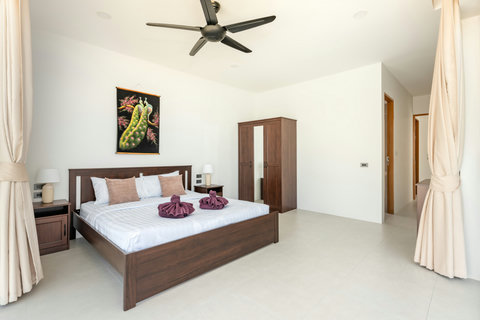 Modern en-suite bathroom with spacious shower, pedestal sink, natural wood accents, and contemporary fixtures
