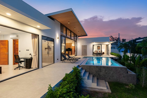 Beautiful villa garden view with modern architecture, lush tropical plants, and green manicured landscaping surroundings