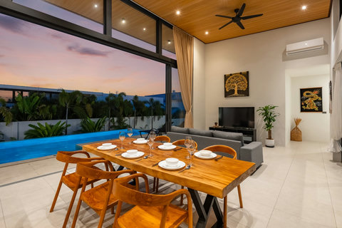Open-concept living and dining area with floor-to-ceiling windows, modern furnishings, and seamless indoor-outdoor space