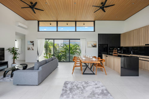 Open-concept living and dining area with floor-to-ceiling windows, modern furnishings, and seamless indoor-outdoor space
