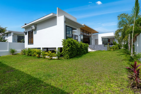 Beautiful villa garden view with modern architecture, lush tropical plants, and green manicured landscaping surroundings