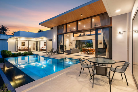 Beautiful villa garden view with modern architecture, lush tropical plants, and green manicured landscaping surroundings