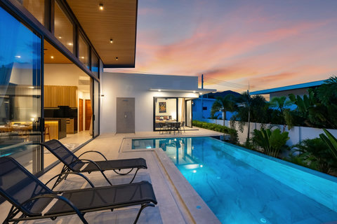 Beautiful villa garden view with modern architecture, lush tropical plants, and green manicured landscaping surroundings