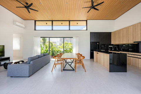 Elegant dining area with teak wood table, perfect for meals with panoramic pool and garden views from the villa