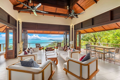 Elegant outdoor dining area at Koh Samui villa with wooden table seating for 10 and panoramic ocean island views