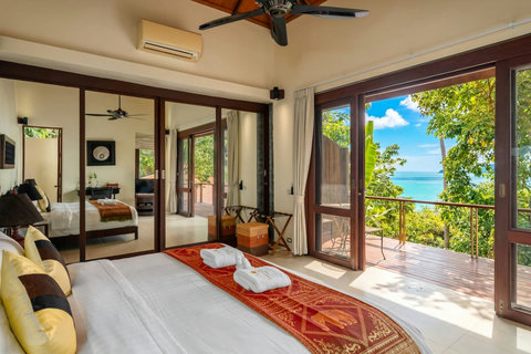 Spacious open-plan living room in Koh Samui villa with floor-to-ceiling windows tropical garden and ocean views