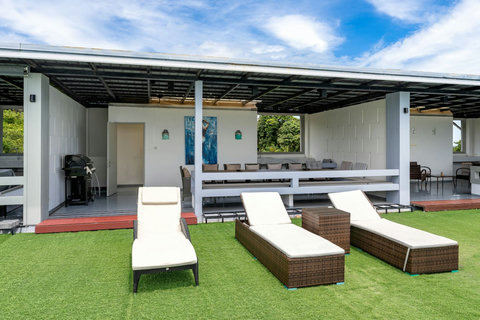 Pool terrace with sun loungers and ocean view at Villa J3, Replay Residence Bangrak Koh Samui