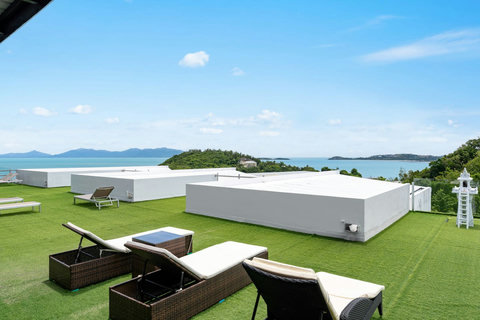 Modern rooftop terrace with glass railings and sea views at Villa J3, Replay Residence Bangrak Koh Samui