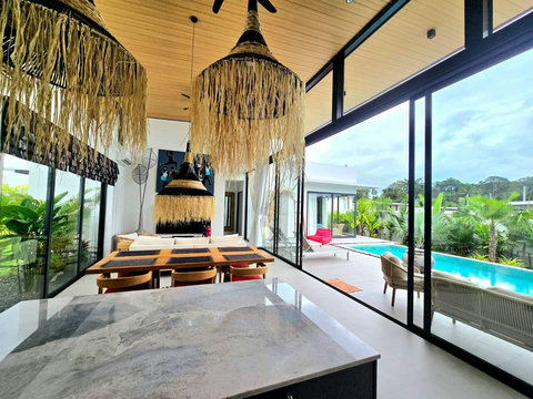 Thatched-roof outdoor lounge with comfortable sofa and pool view