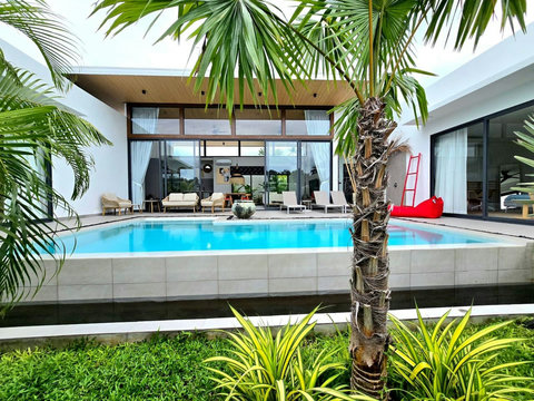 Covered outdoor lounge with stylish seating overlooking the pool