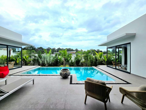 Open-plan living area with glass walls and direct pool access
