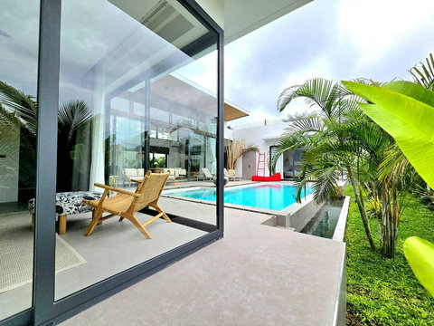 Modern living area with floor-to-ceiling glass walls and garden view