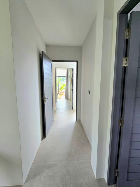 Bright bedroom with wall-mounted TV and ensuite access