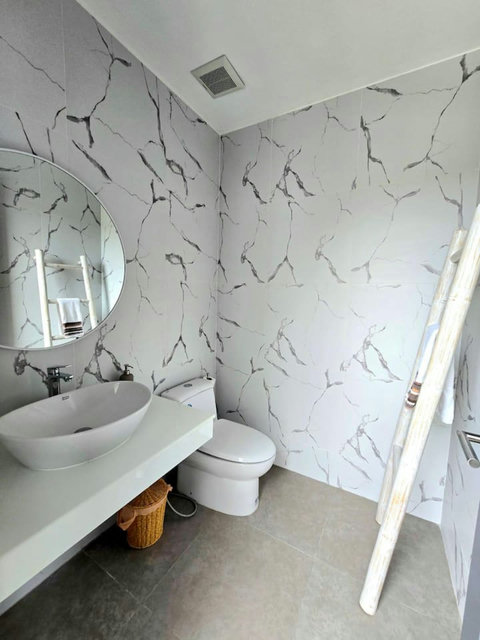 Open-air tropical bathroom with lush garden setting