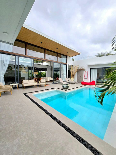 Pool surrounded by palm trees with outdoor dining area