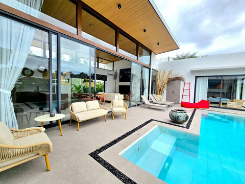 Poolside relaxation area with cushioned daybeds and shade
