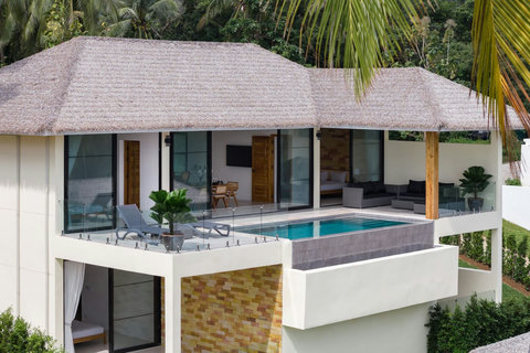 Traditional Thai-style villa exterior with thatched roof and tropical landscaping, Koh Samui