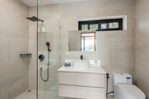 Modern white bathroom with glass walk-in shower and double vanity in Koh Samui vacation rental
