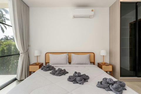 Cozy guest bedroom with crisp white linens and decorative towel art at Sunrise Hill Villa