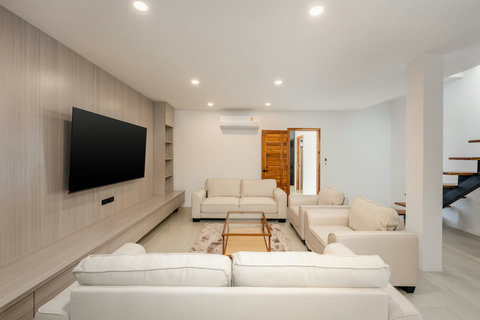 Elegant open-plan living area with feature staircase and TV lounge at Sunrise Hill Villa Koh Samui