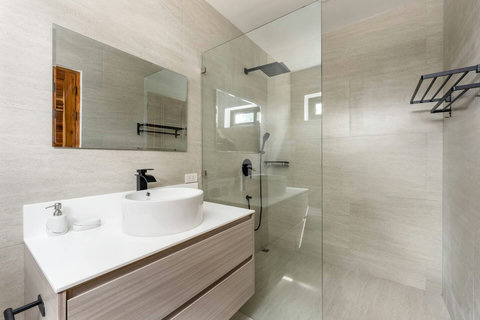 Bright ensuite bedroom with garden views and ceiling fan at Sunrise Hill Villa Koh Samui