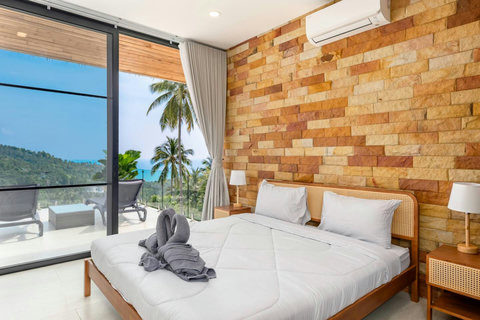Poolside daybed with ocean views and tropical sala at luxury Koh Samui hillside villa