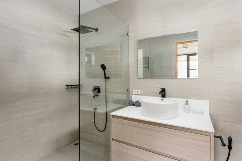 Elegant white bathroom with freestanding bathtub and glass shower at Koh Samui luxury villa