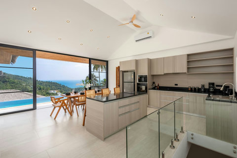 Tropical hillside setting with palm trees and ocean views at Sunrise Hill Villa Koh Samui