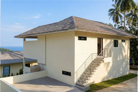 Villa entrance with natural stone walls and covered walkway at Sunrise Hill Villa Koh Samui
