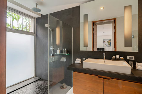 Sleek modern bathroom with dark stone tiles and dual vanity at Laemsingh Villa, Phuket