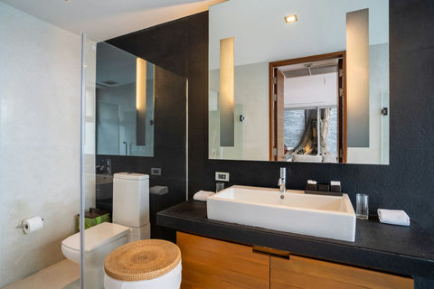 Spa-inspired bathroom with natural stone wall and artisan basin at Laemsingh Villa, Phuket