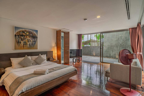 Tranquil bedroom with garden and pool views through floor-to-ceiling glass at Laemsingh Villa