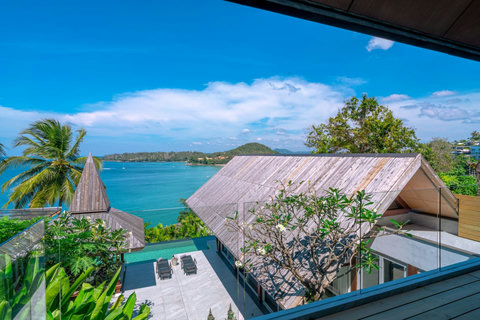 Tropical poolside retreat with palm trees and ocean views at Laemsingh Villa, Phuket