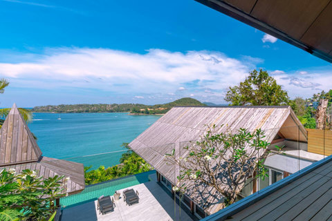 Outdoor dining terrace with ocean views and tropical surroundings at Laemsingh Villa, Phuket