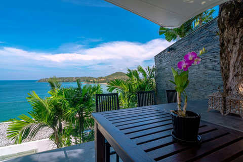 Wooden pool deck with tropical sea views and modern outdoor living at Laemsingh Villa, Phuket