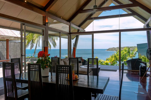 Grand covered verandah with vaulted timber ceiling and tropical views at Laemsingh Villa