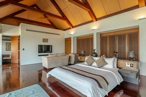 Luxurious bedroom with vaulted wooden ceiling and garden views at Laemsingh Villa, Phuket