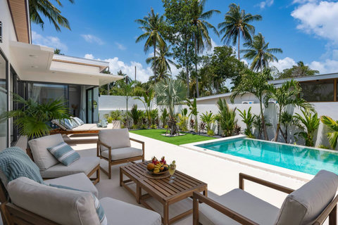 Outdoor lounge with comfortable seating and lush tropical garden at Villa Solunara, Koh Samui