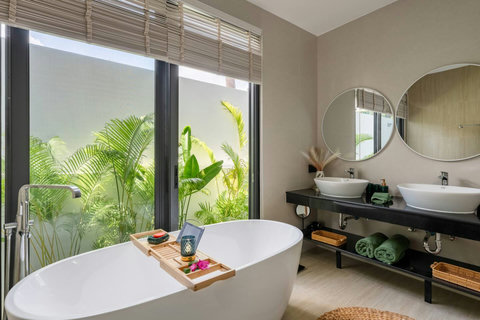 Double vanity bathroom with lush tropical plants at Villa Solunara, luxury Koh Samui villa