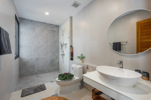 Modern private bathroom with round mirror and bathtub at Villa Solunara, Koh Samui rental