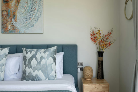 This charming bedroom welcomes you with artistic flair and soft natural light for peaceful rest.
