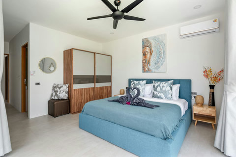 Twin bedroom with vibrant tropical decor and mosquito mesh doors at Villa Solunara, Koh Samui